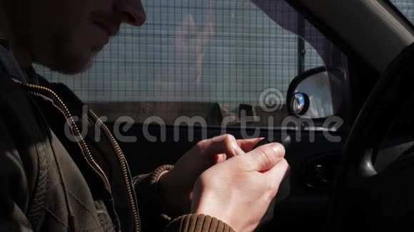 一个穿着皮夹克的男人使用智能手机的特写镜头视频的预览图