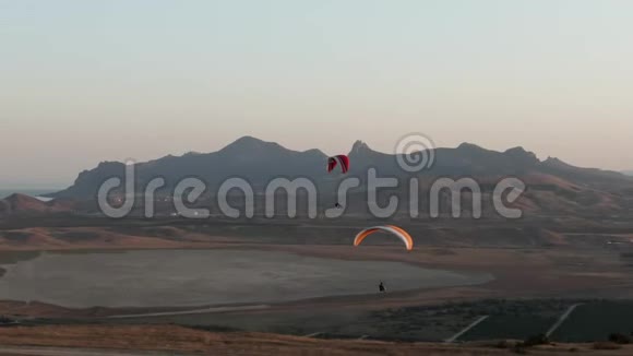 相机和谐而平稳地跟随飞行员带着降落伞运动员的飞行背景视频的预览图