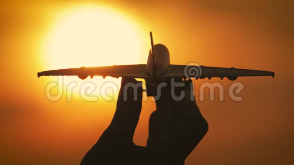在海上日落时女孩手里拿着飞机模型的剪影思想观念视频的预览图