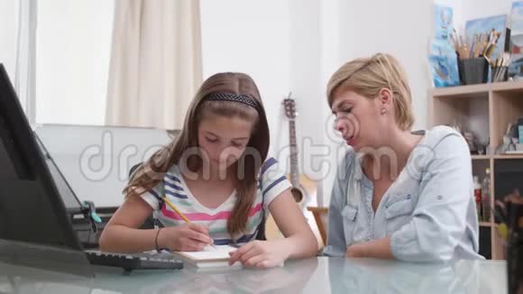 十几岁的女孩在笔记本上画了一些东西妈妈跟她说话视频的预览图