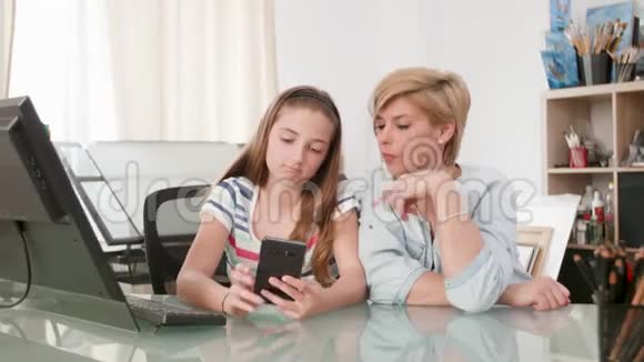 年轻的少女在智能手机上向母亲展示一些东西视频的预览图