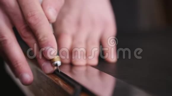 制革工人正在用剃刀和米尺剪黑色的皮视频的预览图
