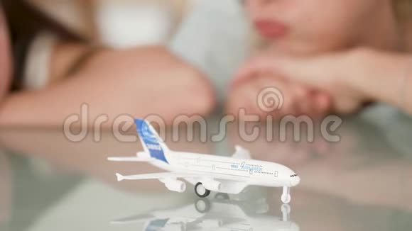 一名年轻女子和一名少女在看玩具飞机时梦想度假的特写镜头视频的预览图