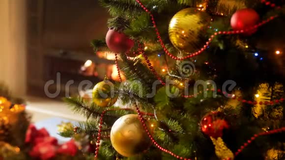 特写4k镜头在夜晚燃烧的壁炉旁圣诞树上发光闪烁的彩色LED灯视频的预览图