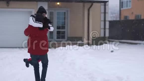 穿着冬装的大胡子男人围着女朋友转都笑了快乐的夫妻在冬天的后院玩得开心视频的预览图