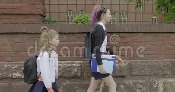 两个女孩上学穿着校服带背包的孩子视频的预览图