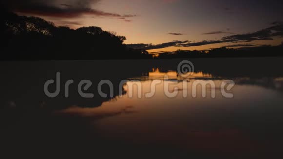 日出时分湖中映出粉红色的云视频的预览图