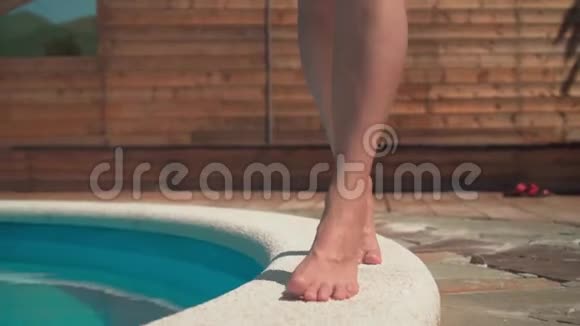 一个女人踮起脚尖沿着池边她的腿特写视频的预览图