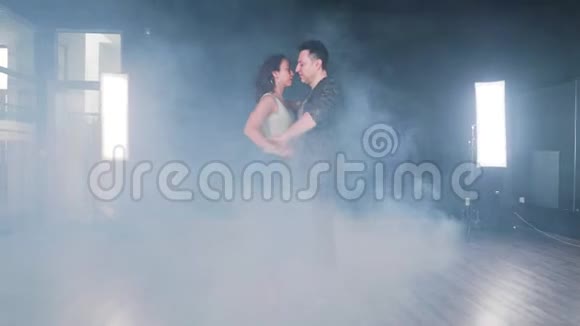 一对夫妇在充满烟雾的舞蹈室里跳舞视频的预览图
