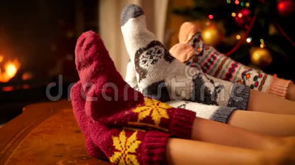 一家人穿着羊毛袜在为庆祝而装饰的客厅壁炉里取暖视频的预览图
