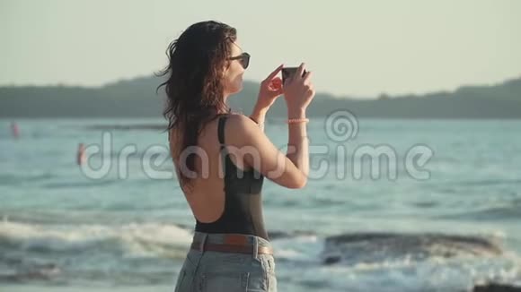 幸福的女人在海上拍日落视频的预览图