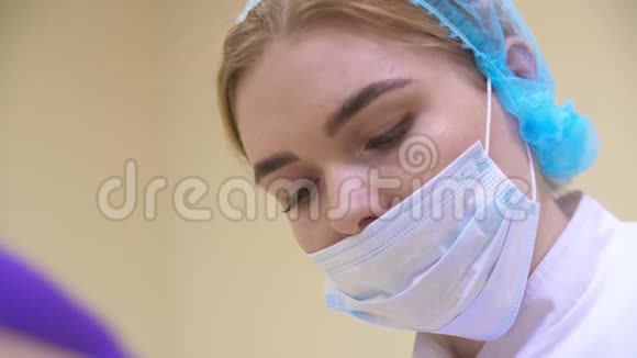 在手术过程中女外科医生的特写镜头俯伏在手术台上的病人身上视频的预览图