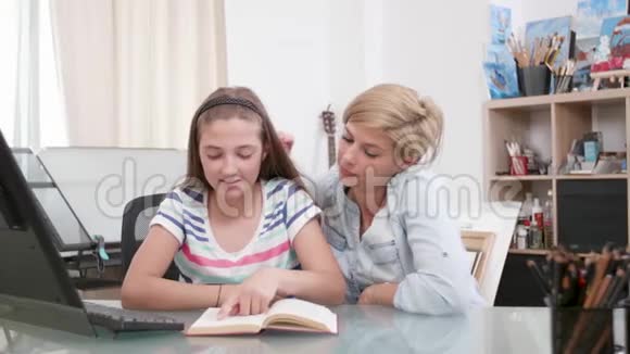 可爱的母亲和她十几岁的女孩一起读一本书视频的预览图