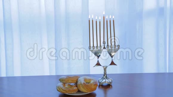 光明节桌上有蜡烛和甜甜圈视频的预览图