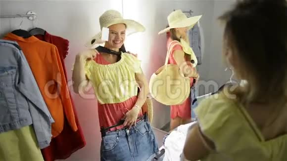 两位时尚女性购物选择礼服服装店里漂亮的年轻购物者视频的预览图