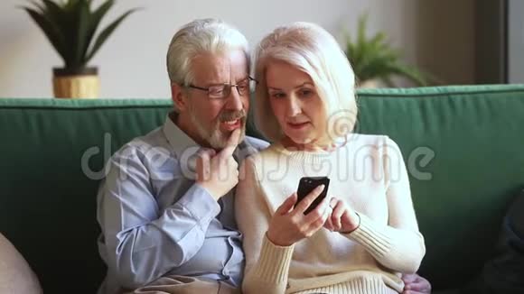 幸福的老夫妇拿着智能手机看着屏幕笑视频的预览图