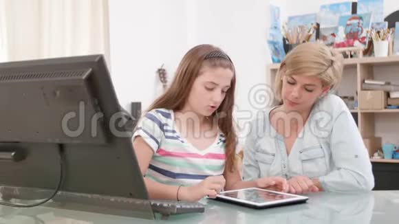 少女在母亲看着屏幕时她在屏幕上滑动平板电脑视频的预览图