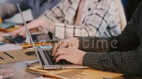 在hackathon会议上男性软件开发人员手拿笔记本电脑在办公桌后工作的特写镜头视频的预览图