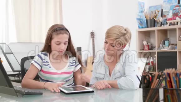 少女使用平板电脑母亲坐在她身边视频的预览图