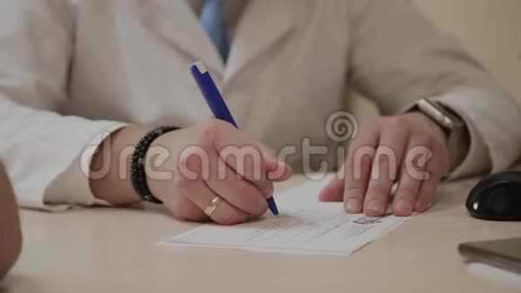 男医生在桌旁的笔记本上写字视频的预览图