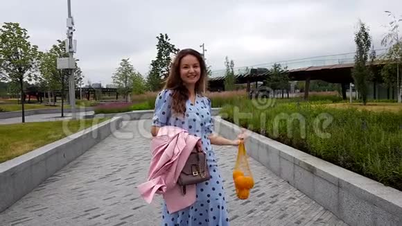 漂亮的女人拿着串袋里的橘子视频的预览图
