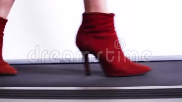 苗条的女人穿着红色靴子的腿穿着细高跟鞋走在T台上展示了一系列新的鞋子视频的预览图