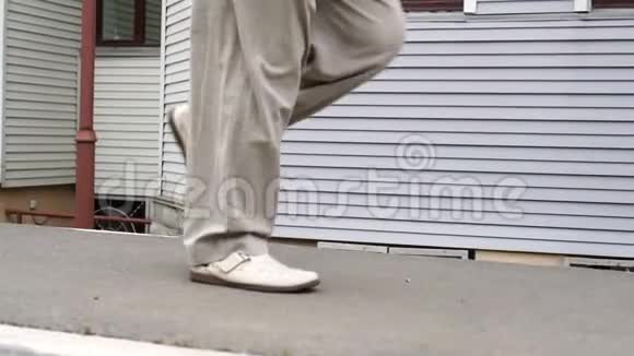 男子双腿穿着白色鞋子在室外的瓷砖路上奔跑视频的预览图