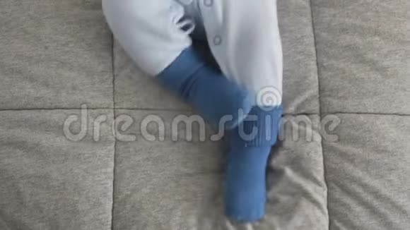 婴儿穿着蓝色袜子移动她的腿特写视频的预览图