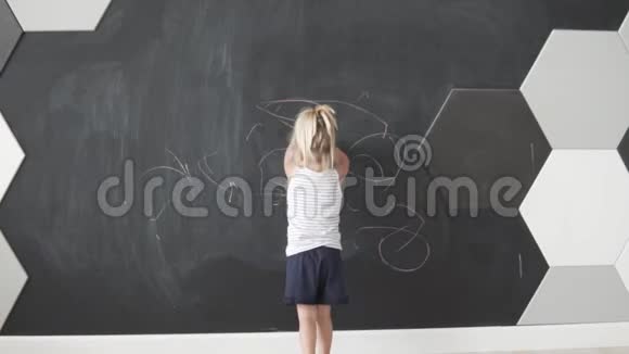 一个小女孩把粉笔从黑板上擦掉视频的预览图
