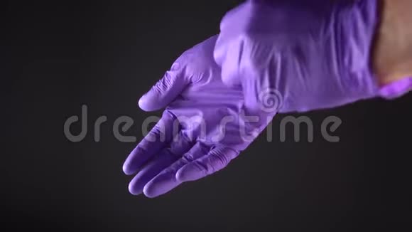 一个男人从两只手中摘下他的蓝色防护手套视频的预览图