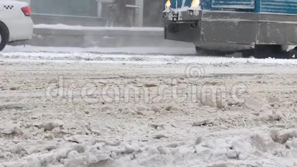 大雪后覆盖着潮湿的脏雪的巷道以及在其上行驶的汽车的下部橙色视频的预览图