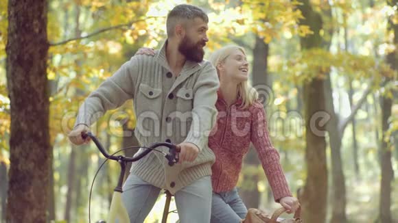 浪漫的秋天情侣相爱欢快的年轻女子和留着秋叶胡子的男人的肖像秋天的美丽视频的预览图