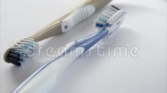 两个塑料牙刷在灰色背景下旋转特写视频的预览图