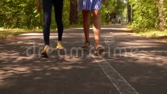 两个十几岁的女孩朋友一起在公园散步手牵着手腿特写视频的预览图