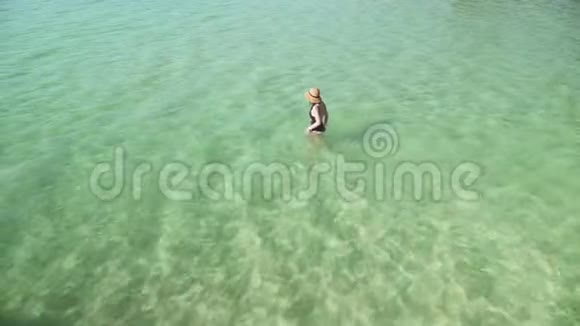 女人进入透明的彩色水中游泳视频的预览图