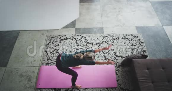 城市阁楼设计在客厅女士练习瑜伽在家里捕捉视频从阁楼顶部视频的预览图