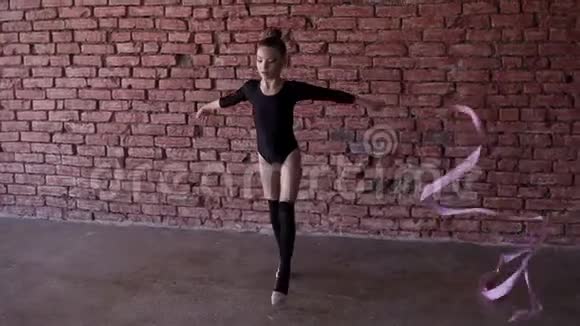 年轻的女舞者在舞厅里训练小女孩跳舞做不同的芭蕾舞动作爱好和健康视频的预览图