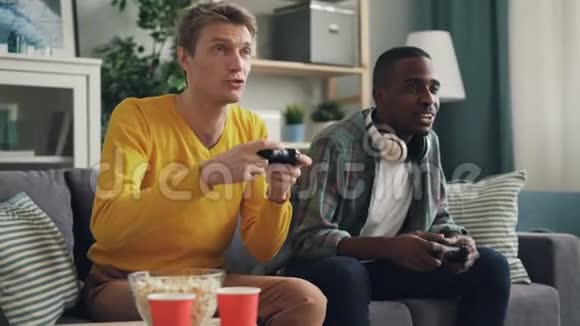 非裔美国人和高加索人正在玩电子游戏然后做击掌和握手现代技术视频的预览图