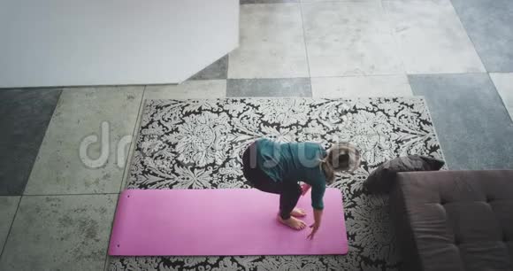 瑜伽姿势在早晨女士在家里练习在客厅里她有一个伸展的身体穿着舒适视频的预览图