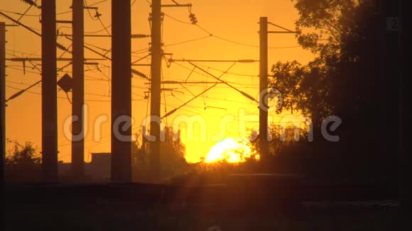 在落日的轮廓上的铁路水平交叉电气化铁路太阳在地平线上工作日结束视频的预览图