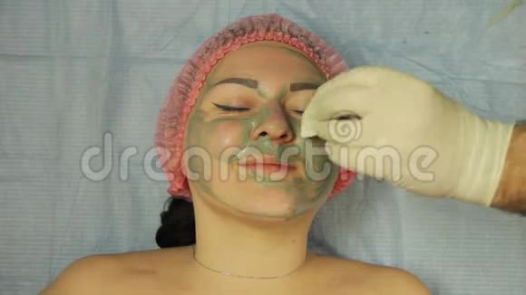 美容师双手戴着手套用棉垫把口罩从女人脸上移开视频的预览图