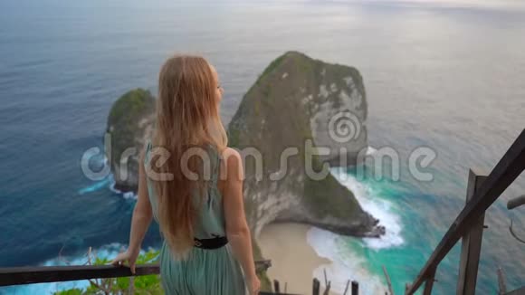 年轻女子游客参观所谓的暴龙岩在克林金海滩努沙佩尼达印度尼西亚著名的视频的预览图