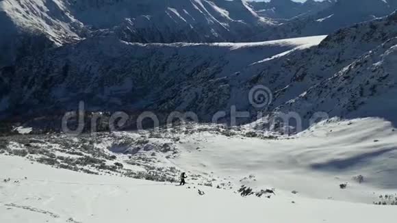 冬天的时候人们在雪山上滑雪晴朗的一天有蓝天的景观滑雪道Pirin山峰风景如画视频的预览图