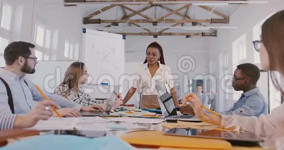 自信的非裔美国女商人在会上用五彩纸屑庆祝成功快乐的年轻多民族团队视频的预览图