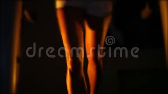 美丽的晒黑的女性腿在黑暗中在跑步机上跑步视频的预览图