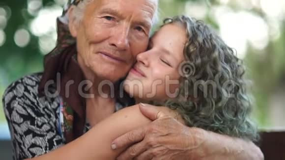 祖母和孙女拥抱的亲密肖像一个戴头巾的老妇人和一个染染的少女视频的预览图