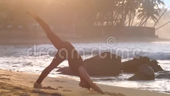 年轻的赤脚女子在沙滩上改变瑜伽姿势视频的预览图