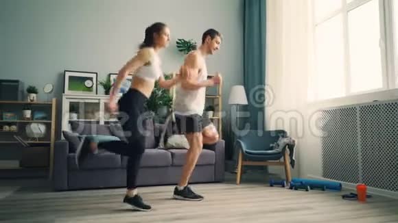 年轻女孩和穿运动服装的男人在家跑步一起做运动训练视频的预览图