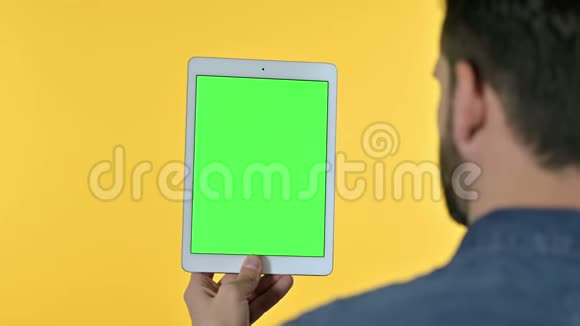 人在平板上滚动带有彩色屏幕黄色背景视频的预览图