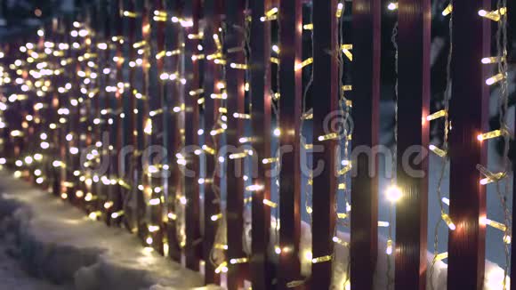 圣诞节闪光的花环在篱笆上夜晚的装饰照明除夕夜开始的概念视频的预览图